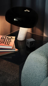 AVOLT Square 1 USB-C Swiss power cube on bedside table beside lamp and books
