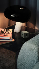 AVOLT Square 1 USB-C (Swiss) mini power cube on bedside table, green finish, cord plugged next to lamp and books