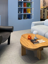 Orange AVOLT Square 1 on a wooden coffee table, with a colour display behind the seating area.